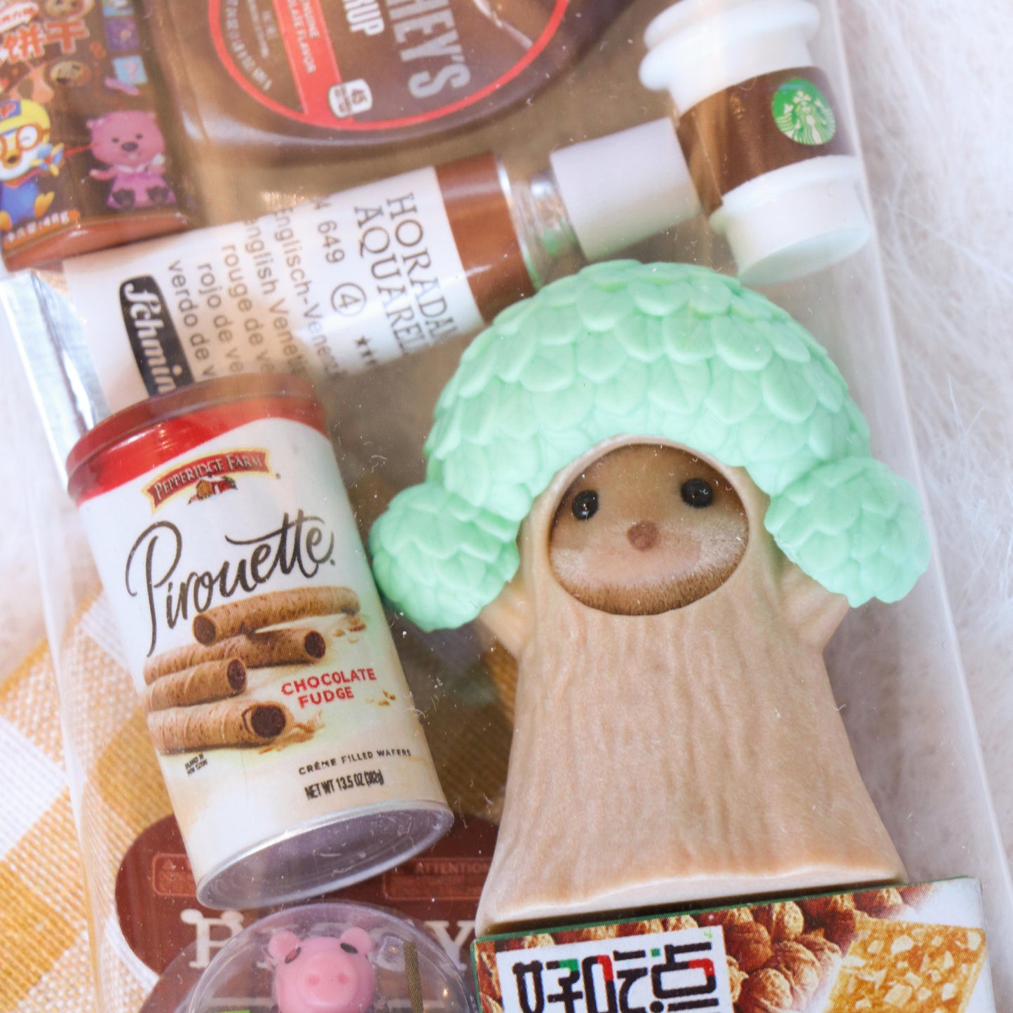 Assorted snacks and a small figurine on a checkered fabric background
