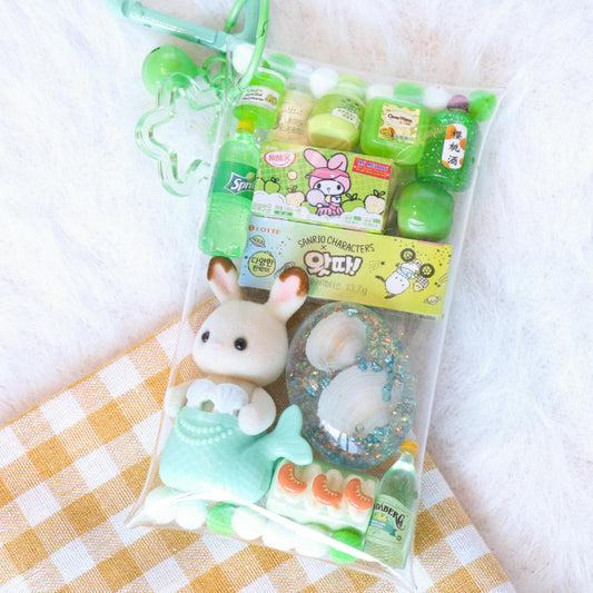 Packaged toy with a green heart-shaped holder on a checkered fabric background