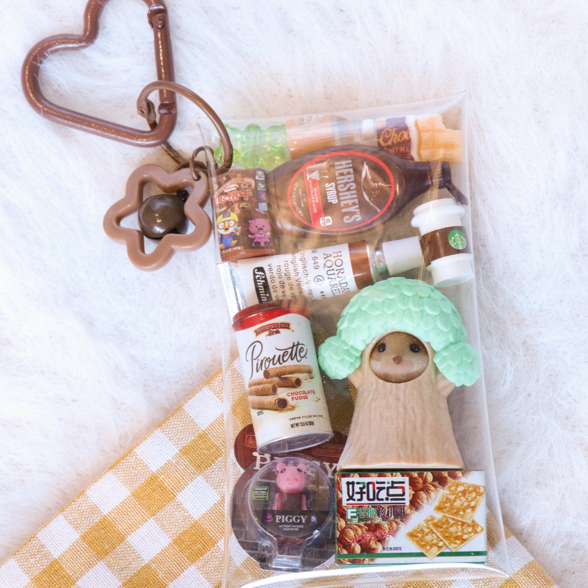 Packaged snacks with a heart-shaped keychain on a checkered fabric background