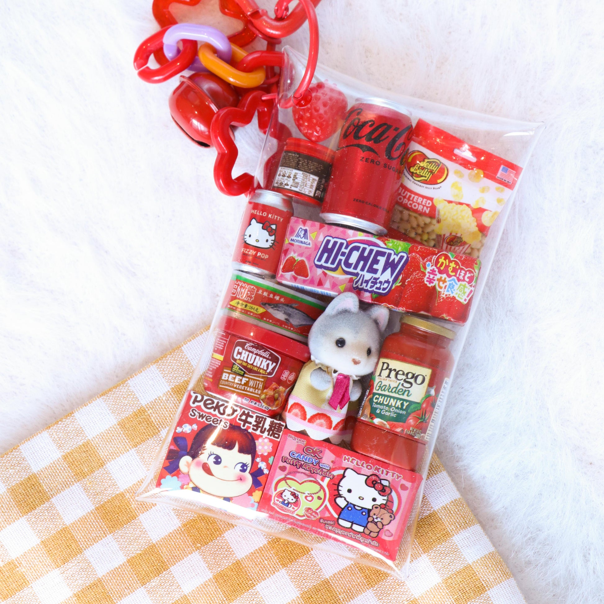 Packaged snacks with a heart-shaped keychain on a checkered fabric background