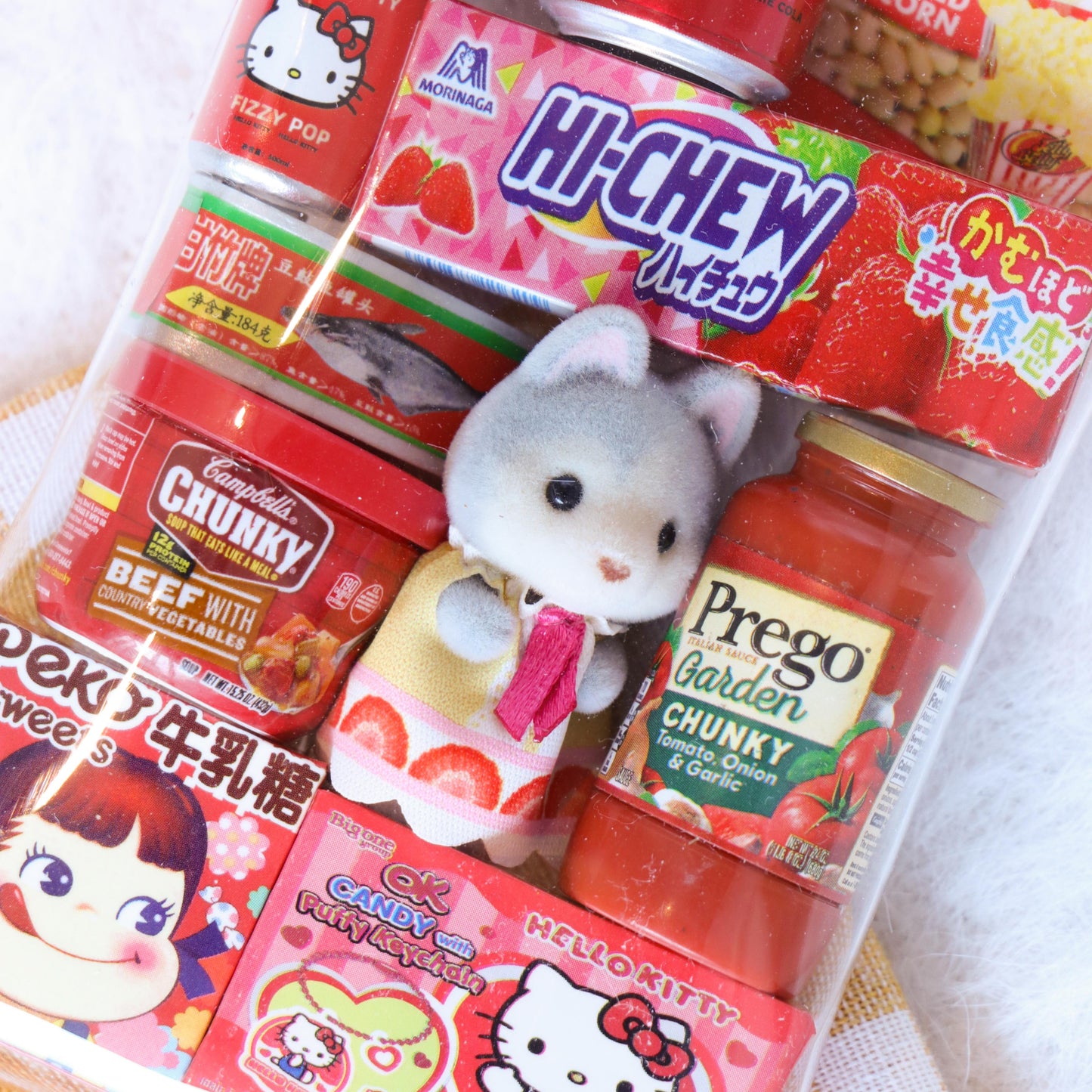 Assorted snacks including a small plush toy on a checkered tablecloth.
